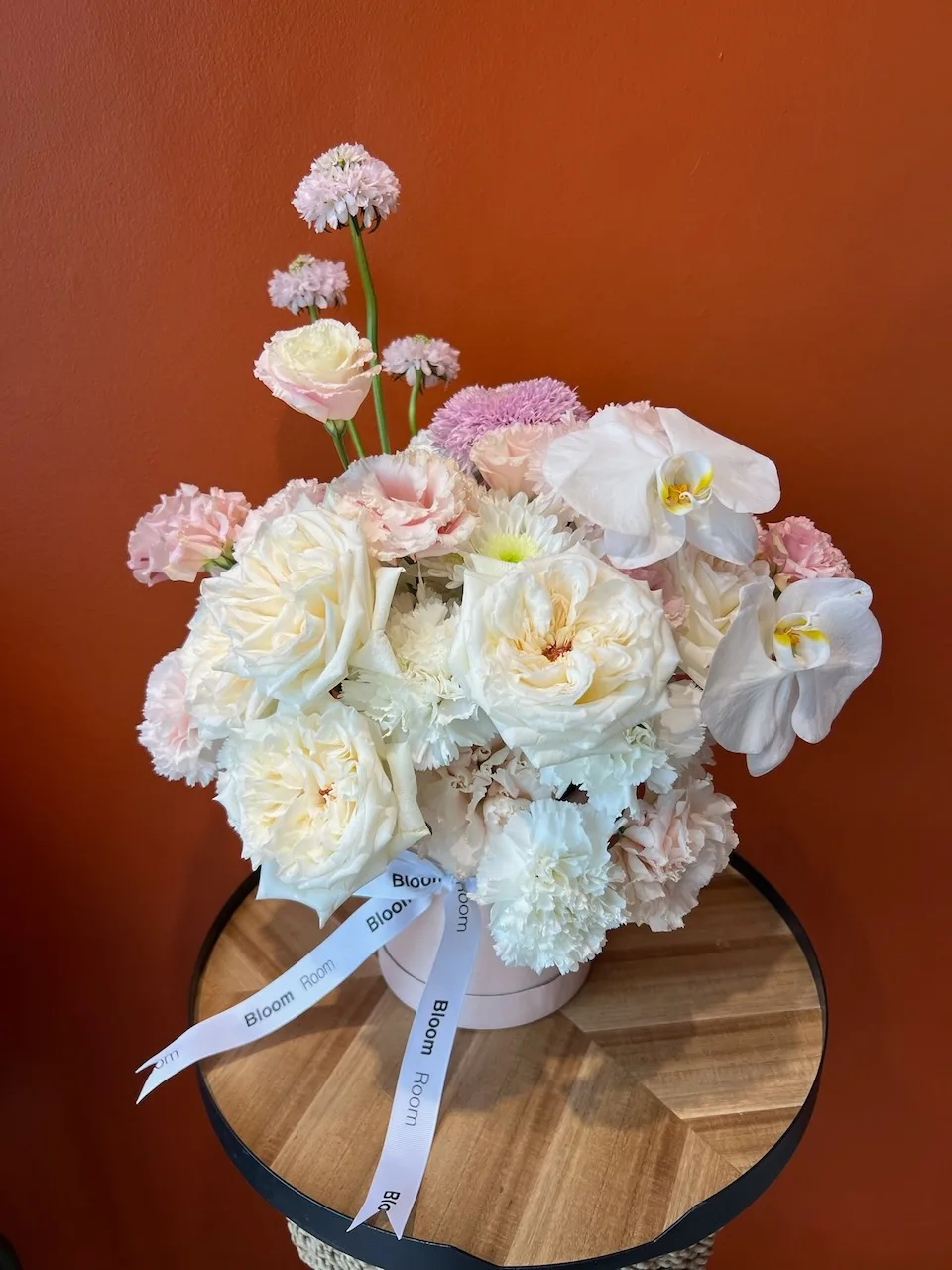 Small pastel orchid and rose arrangement for a place setting