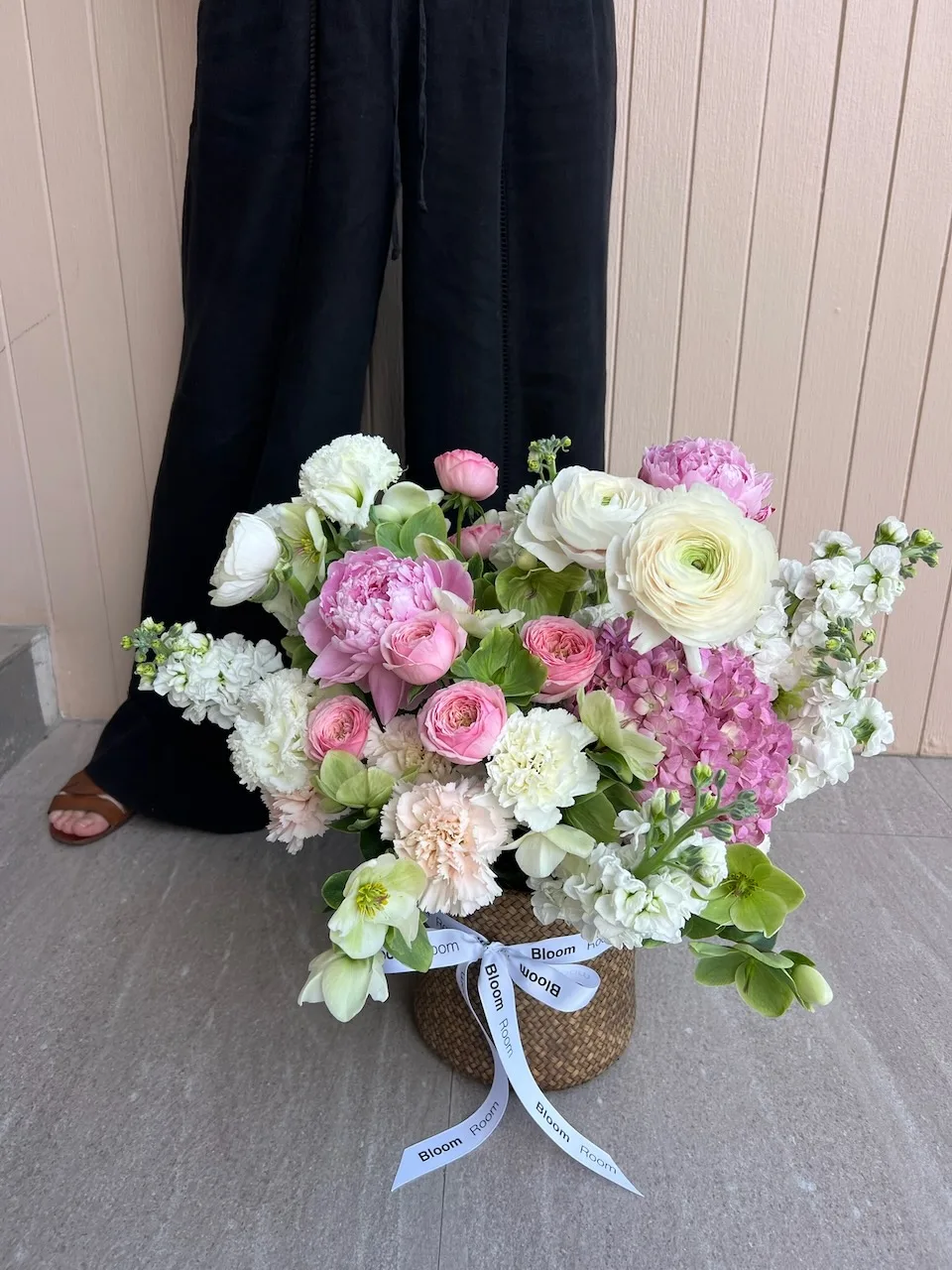 Lush basket arrangement with pink hydrangeas, white ranunculus and roses