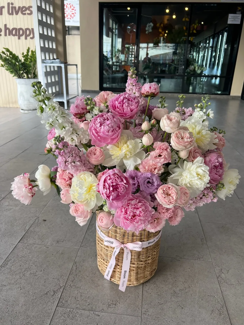 Pink peony and daffodil arrangement in a wicker basket by Bloom Room Studio, Koh Samui