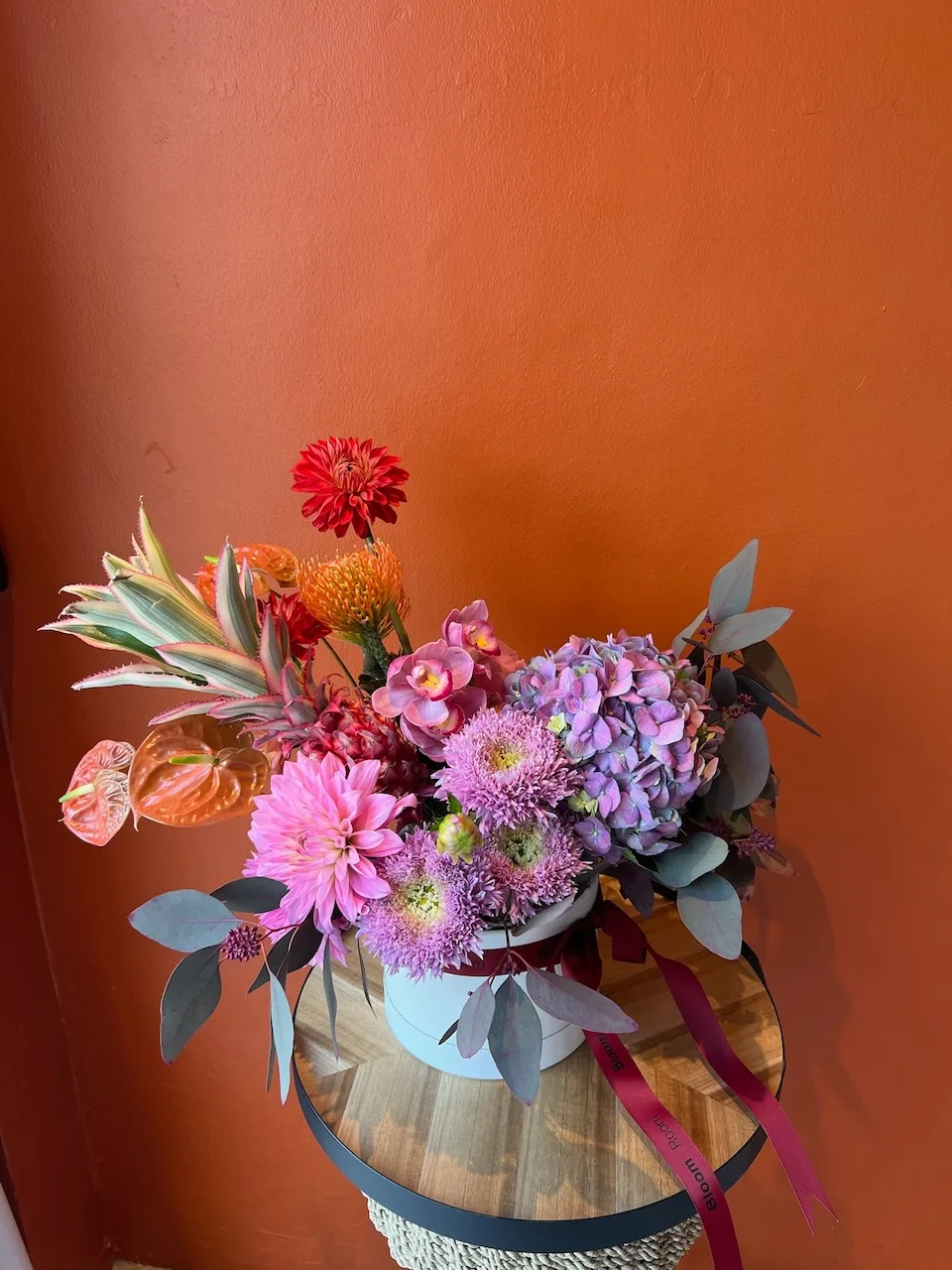 Grand white hatbox with red dahlias, pincushion protea, purple hydrangea, anthurium and eucalyptus