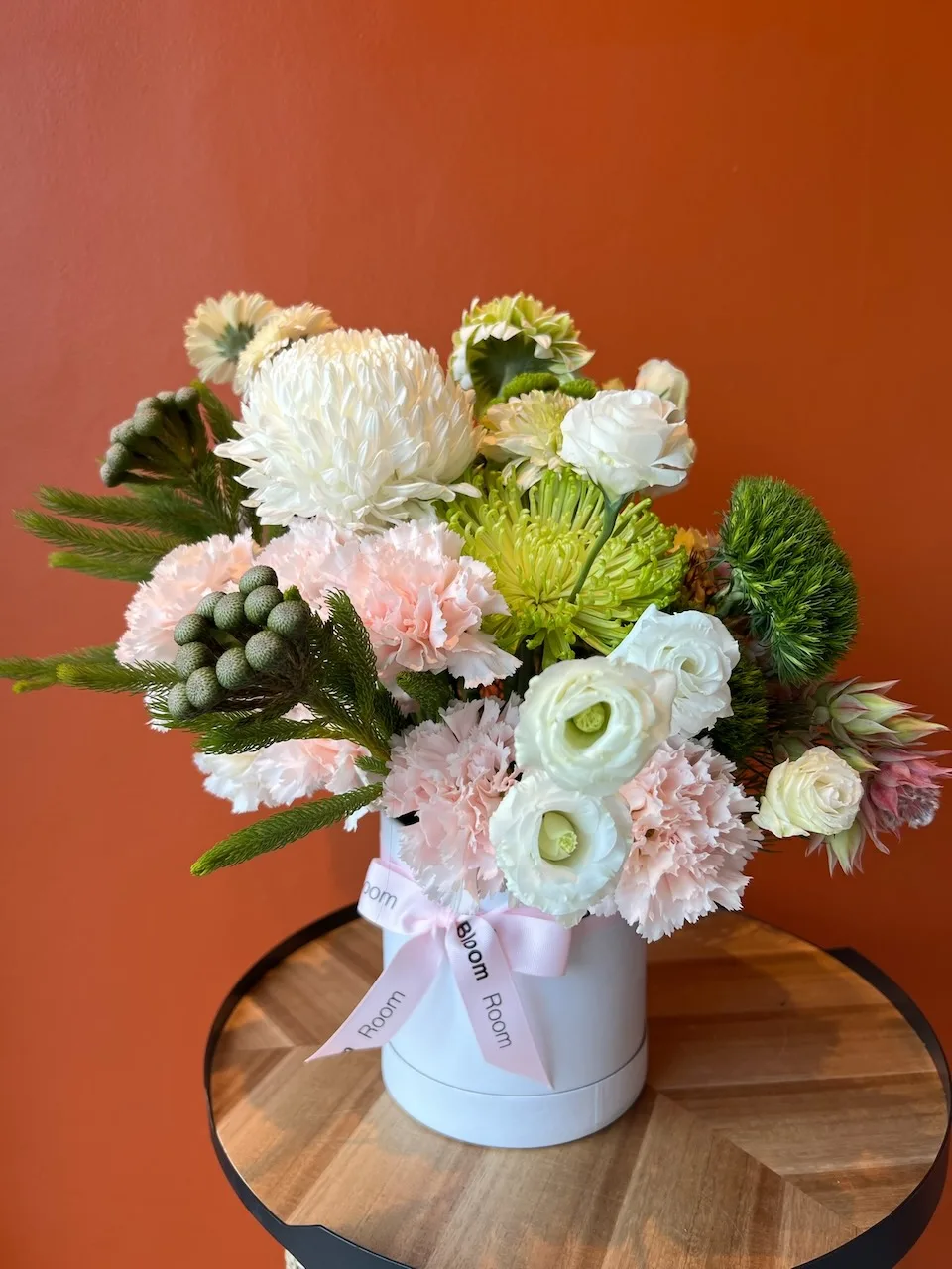 White chrysanthemum, carnations and ranunculus with green accents in a white box