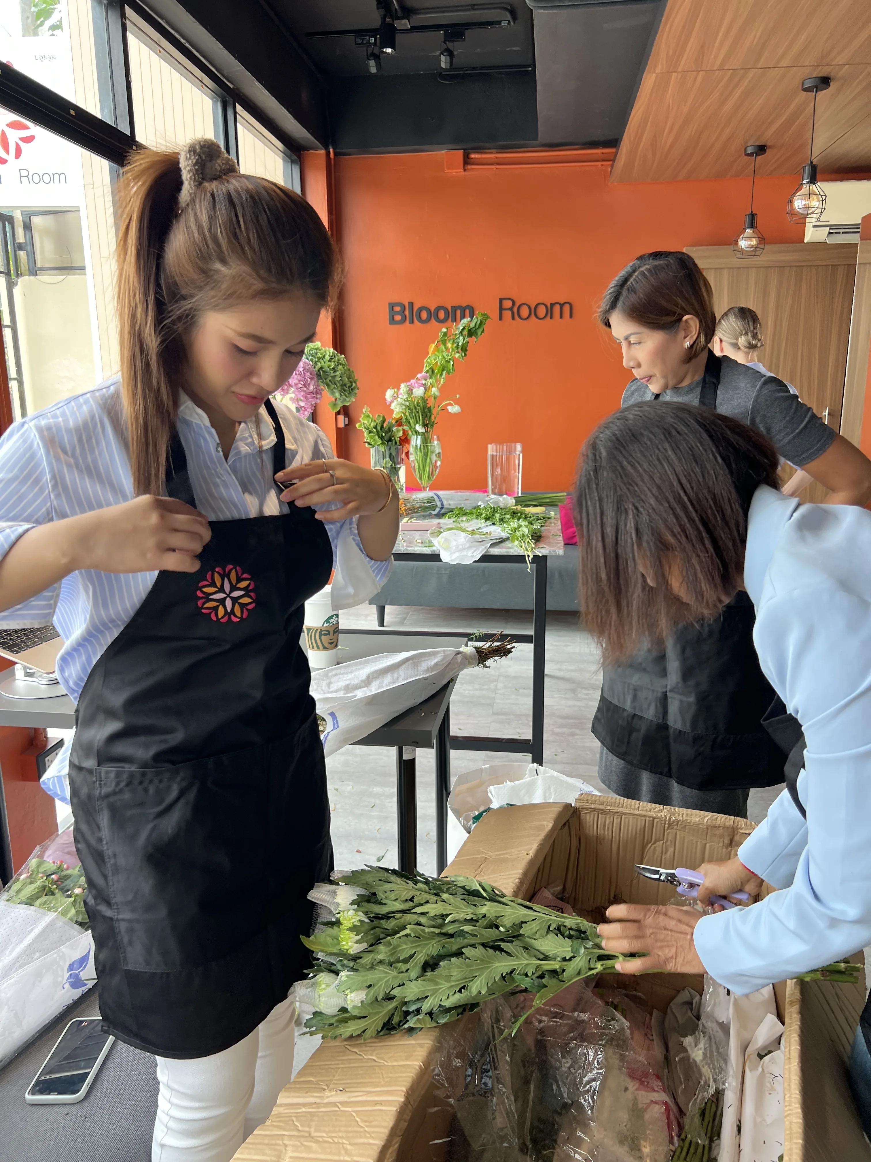 The team gathered around the studio workbench preparing flowers