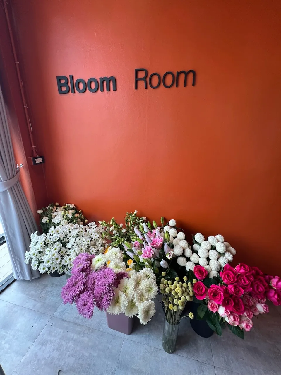 The Bloom Room storefront sign with flowers around it